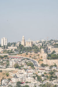 Aerial view of buildings in city against clear sky