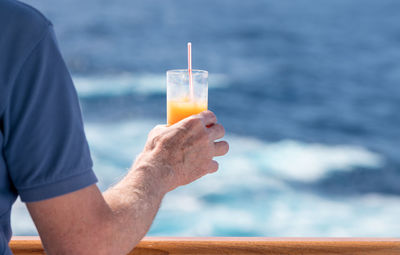 Midsection of man holding ice cream against blurred background