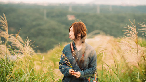 Beautiful young woman standing at farm