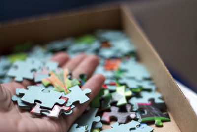 Close-up of colored puzzles on the human hand