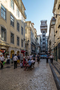 People on street against buildings in city