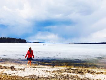 Young woman standing at beach during winter