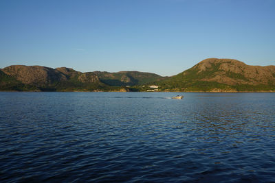 Scenic view of sea against clear blue sky