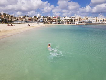 Person swimming in sea against sky