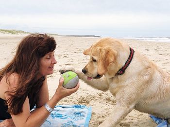 Young woman with dog on beach