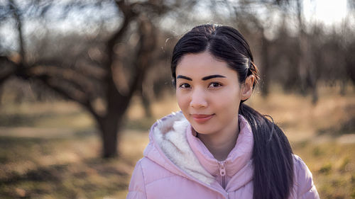 Portrait of beautiful woman standing on field