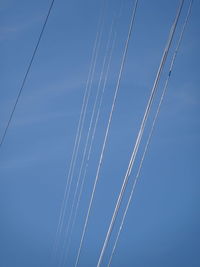 Low angle view of cables against blue sky