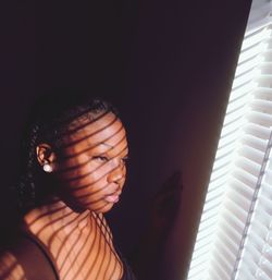 Woman looking through window at home