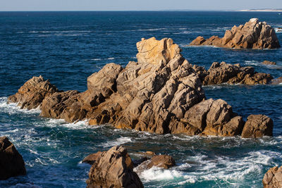 Scenic view of rocks in sea against sky