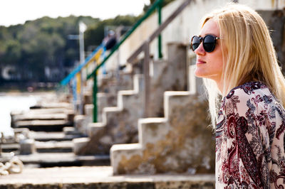 Side view of young woman wearing sunglasses at outdoors