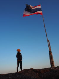 Low angle view of woman standing at beach against clear sky