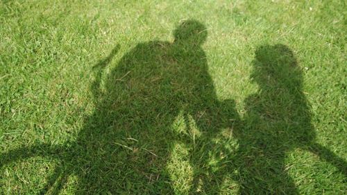 High angle view of people shadow on grassy field