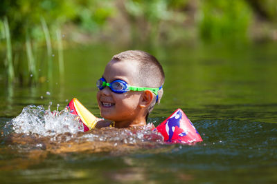 Smiling boy swimming at lake