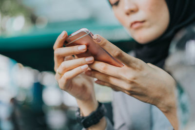 Midsection of man holding mobile phone