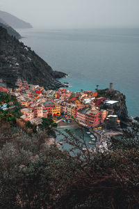 High angle view of townscape by sea against sky