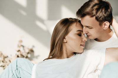 Portrait of two beautiful caucasian white people in love smiling with closed eyes