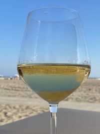 Close-up of beer glass on sand