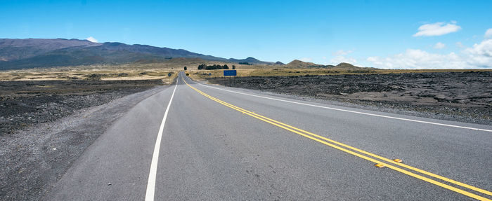 Empty road along countryside landscape
