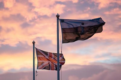 Low angle view of flags against sky during sunset