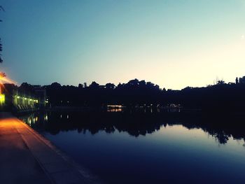 Scenic view of lake against clear sky during sunset