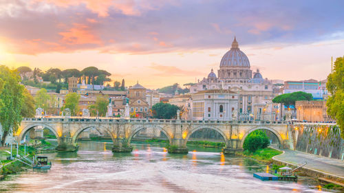 Arch bridge over river during sunset