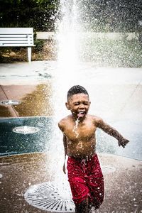 High angle view of boy enjoying in fountain