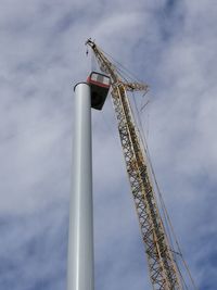 Low angle view of crane against sky