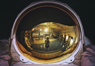 Reflection of people photographing in illuminated mirror