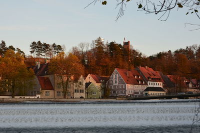 Houses by trees against sky