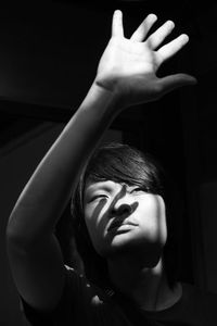 Sunlight falling on young man gesturing in darkroom