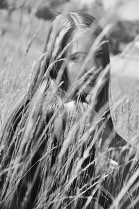 Woman sitting amidst crops on field