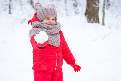Portrait of smiling girl standing on snow