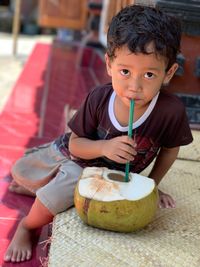 Portrait of boy drinking coconut water 