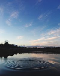 Scenic view of river against sky at sunset