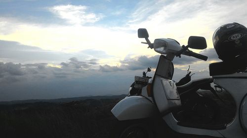 Motorcycle on landscape against sky