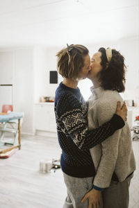Affectionate lesbian couple kissing each other at home