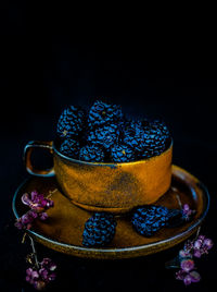 Close-up of purple served on table against black background