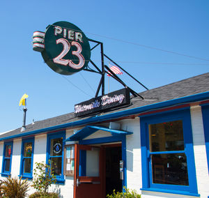 Low angle view of information sign against clear blue sky