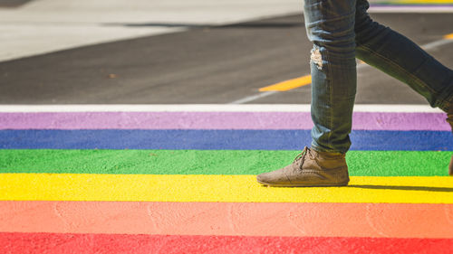 Low section of man standing on multi colored street