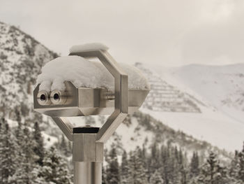 Close-up of binoculars against foggy sky