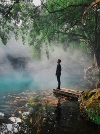 Full length of man standing on rock against trees