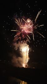 Low angle view of firework display at night