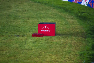 Close-up of red signboard on field