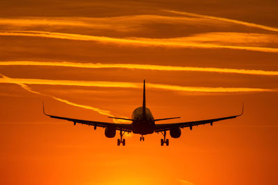 Airplane flying in sky during sunset