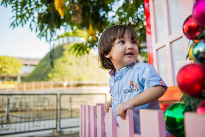 Girl looking away while standing against blurred background