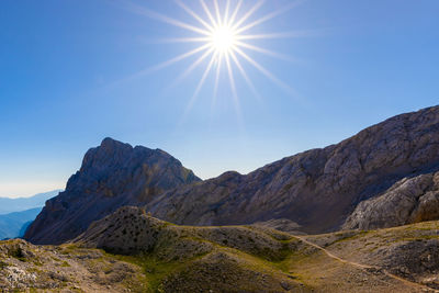 Scenic view of mountains against sky on sunny day