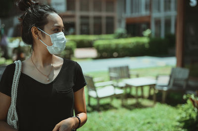 Young woman carrying reusable bag walking in public community area , refreshing look and travel 