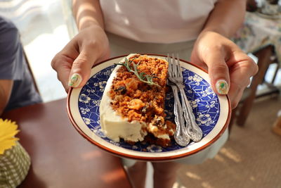 Midsection of person holding food in plate