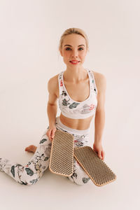 Fitness girl in sportswear trains does sports with bare feet standing on nails.solstice. sadhu board