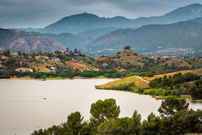 Scenic view of river and mountains against sky